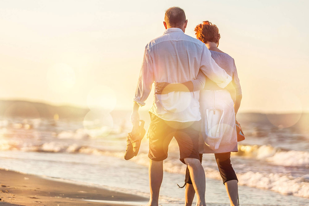 Retired couple walking on the beach